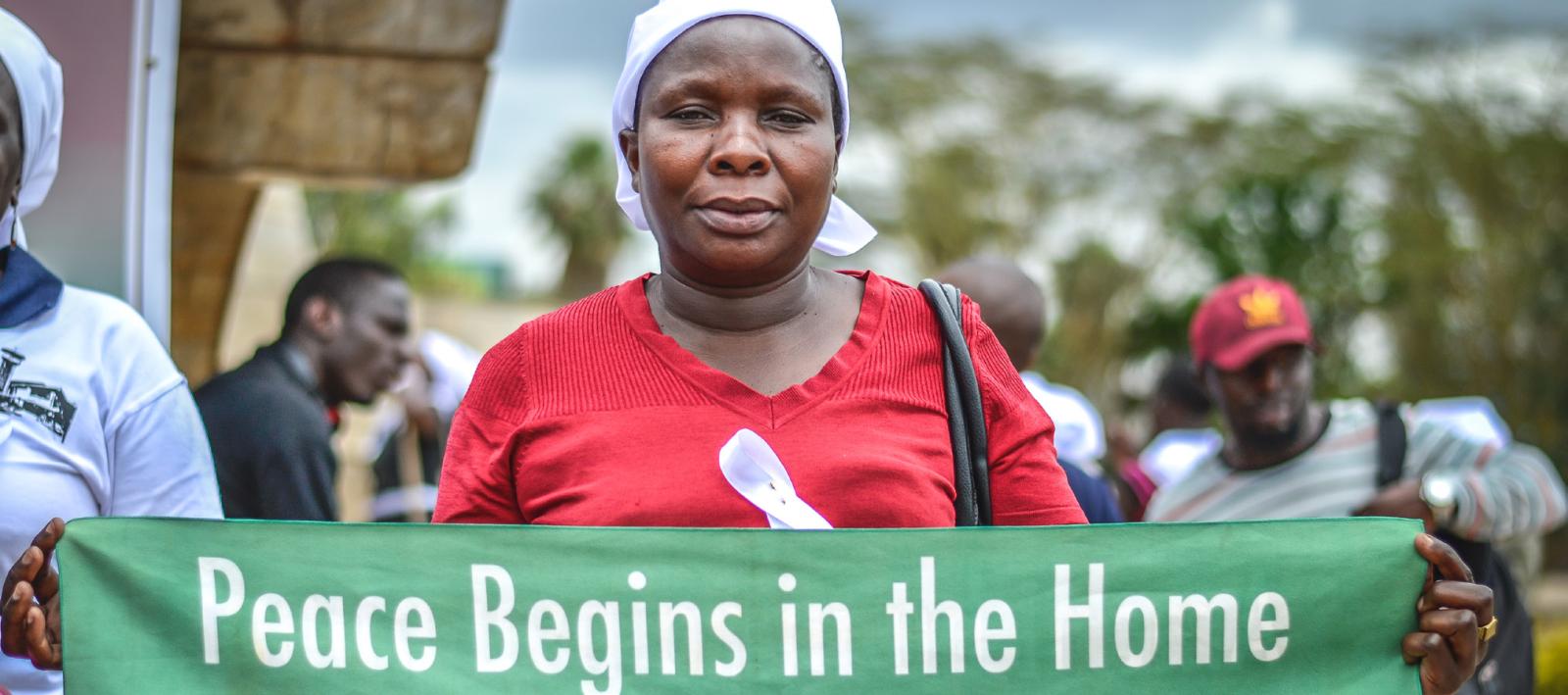 A Kenyan woman holding peace campaign banner